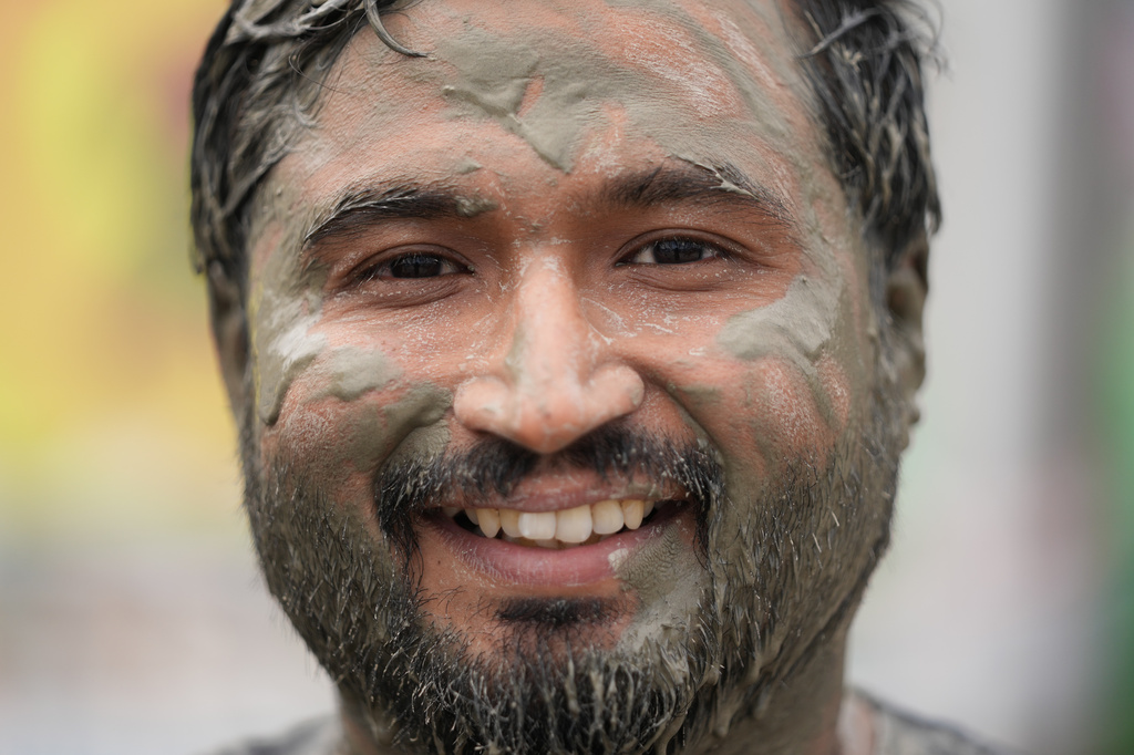 Shyam Vasvani from India, covered in mud, poses for a photo during the Boryeong Mud Festival near a beach in Boryeong, South Korea, Saturday, July 25, 2026. (AP Photo/Lee Jin-man)