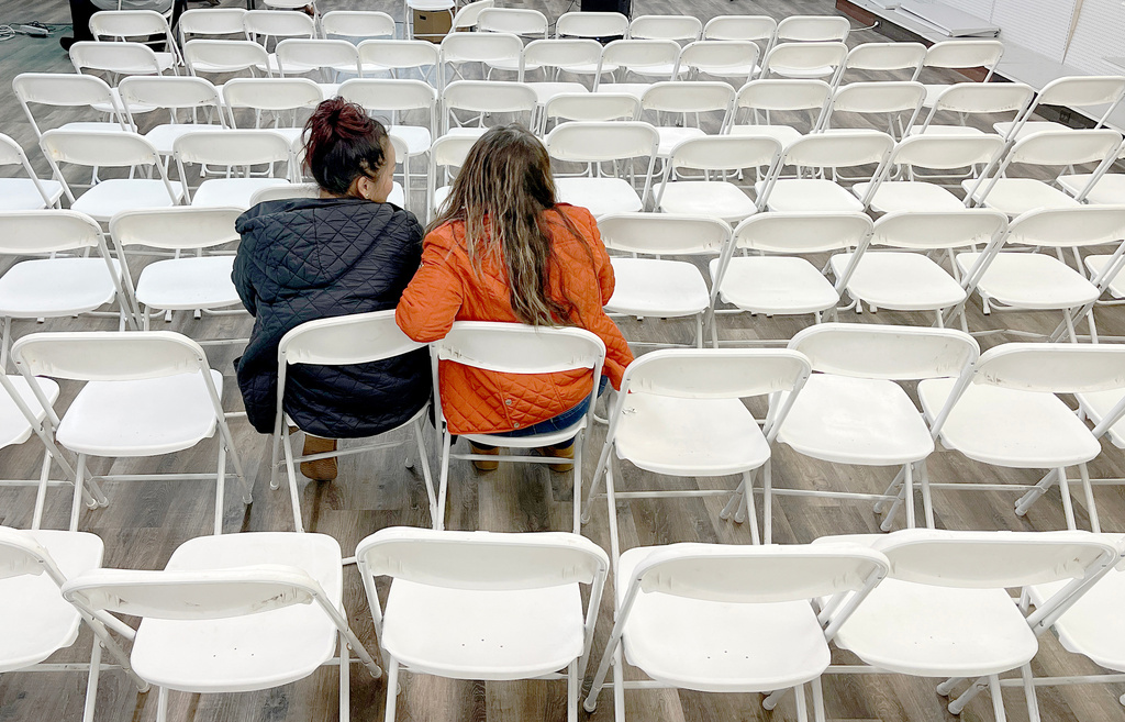 Two women listen during an informational meeting held by the Nebraska Department of Labor for Tyson Foods employees in Lexington, Neb., Thursday, Dec. 4, 2025. (AP Photo/Thomas Peipert)