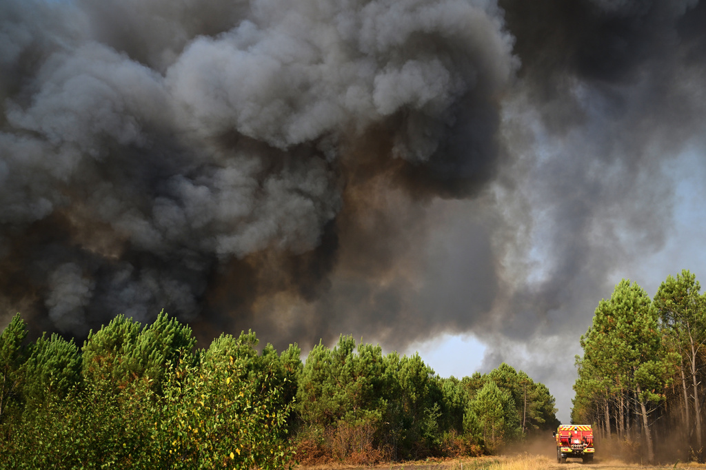 A smoke cloud rises as firefighters work to extinguish a fire in the forest near Blagon, during wildfires in southwestern France, Wednesday, July 29, 2026. (AP Photo/Emma Da Silva)