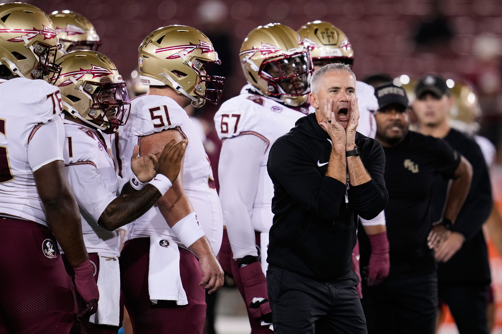 Florida State head coach Mike Norvell, right, gestures as players warmup before an NCAA college football game against Stanford, Saturday, Oct. 18, 2025, in Stanford, Calif. (AP Photo/Godofredo A. Vásquez)
