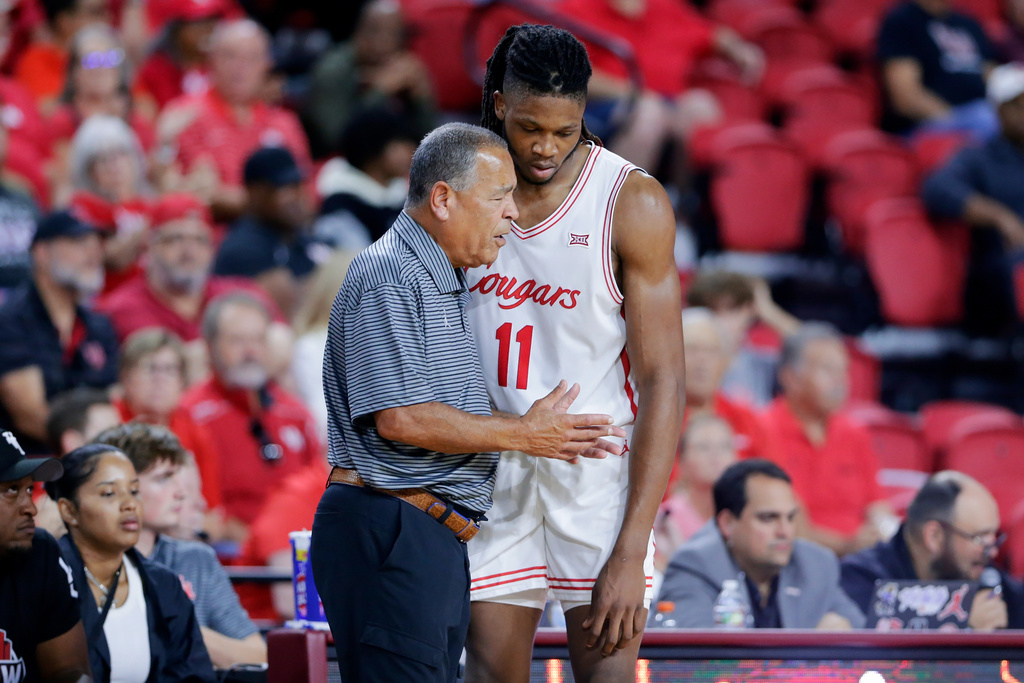Houston head coach Kelvin Sampson, left, talks with forward Joseph Tugler (11) at the bench during the second half of an NCAA college basketball exhibition game against Mississippi State, Sunday, Oct. 26, 2025, in Rosenberg, Texas. (AP Photo/Michael Wyke)