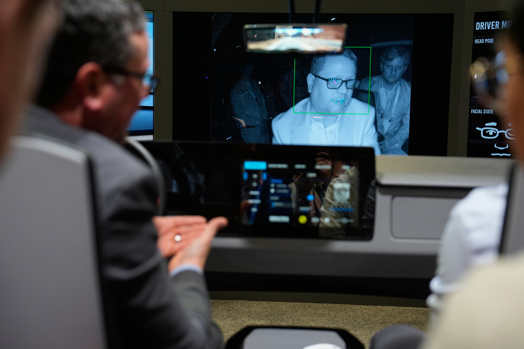 People experience a Gentex Corporation driver and in-camera monitoring system exhibit during the CES tech show Tuesday, Jan. 6, 2026, in Las Vegas. (AP Photo/John Locher)