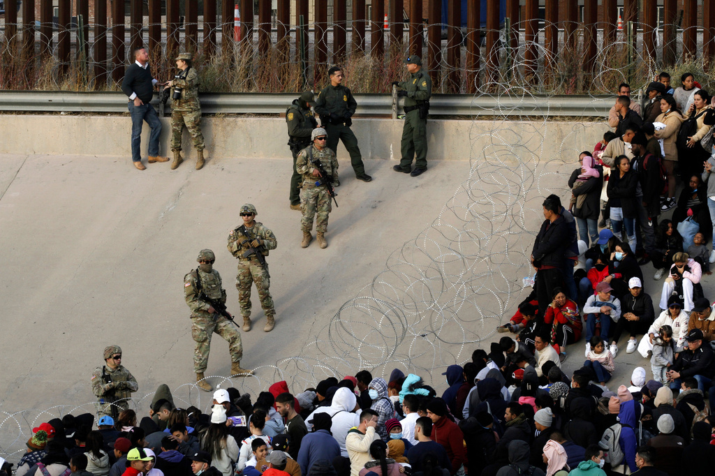 FILE - Migrants congregate on the banks of the Rio Grande at the U.S. border with Mexico on Dec. 20, 2022, where members of the Texas National Guard cordoned off a gap in the U.S. border wall. (AP Photo/Morgan Lee, File)