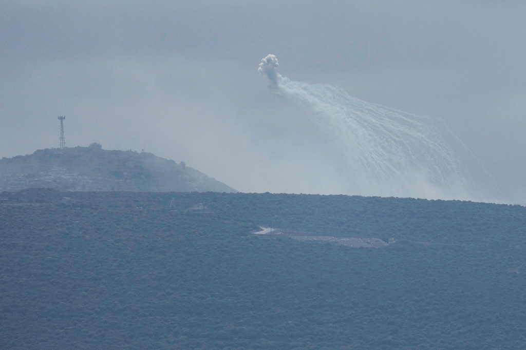 A shell that appears to be white phosphorus from Israeli artillery explodes over a road leading to Chamaa village, as it is seen from Tyre city, south Lebanon, Friday, March 27, 2026. (AP Photo/Hussein Malla)