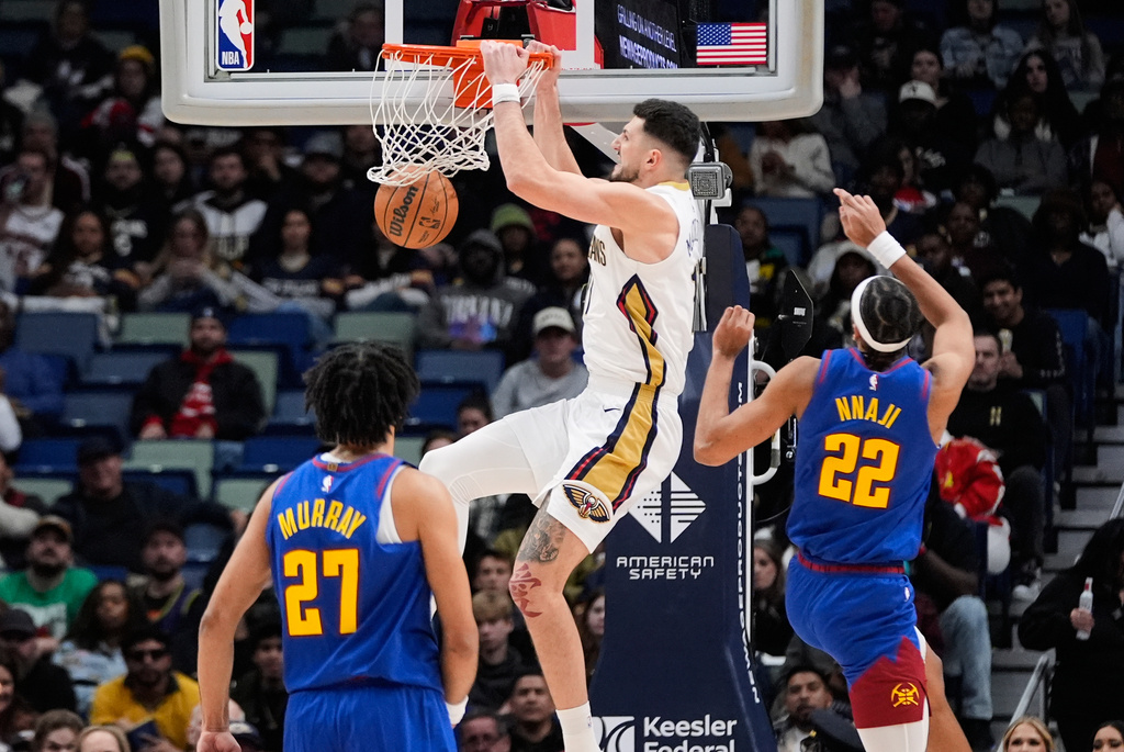 New Orleans Pelicans forward Karlo Matkovic (17) slam dunks between Denver Nuggets forward Zeke Nnaji (22) and guard Jamal Murray (27) in the second half of an NBA basketball game, Tuesday, Jan. 13, 2026, in New Orleans. (AP Photo/Gerald Herbert)