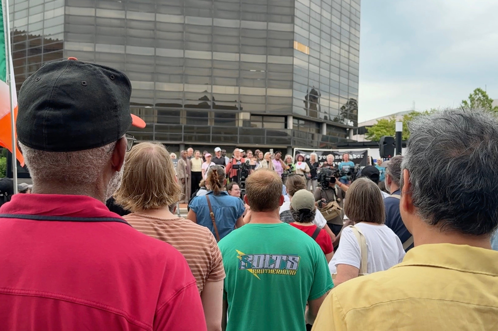 This photo made from video shows residents watching members of a choir sing while attending a rally in support of Haitian people on Thursday, June 25, 2026, in Springfield, Ohio, after the United States Supreme Court ruled that the Trump administration is allowed to end TPS for Haitians and Syrians. (AP Photo/Patrick Aftoora-Orsagos)