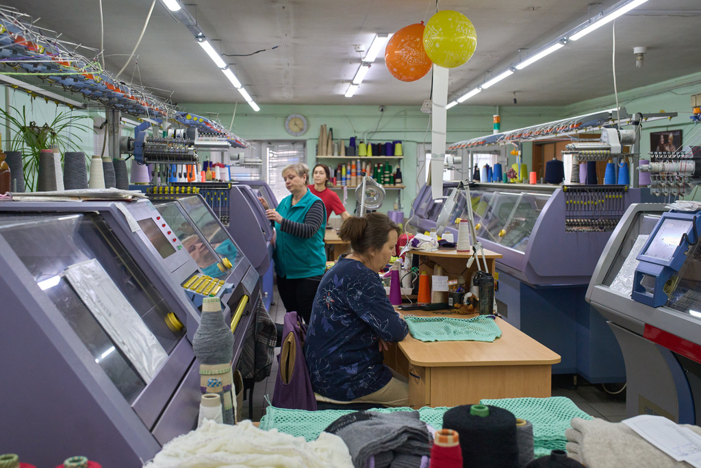 Employees of the Rito Group, a clothing company that produces knitwear, work on a generator during a blackout caused by Russia's regular air attacks on the country's energy system Friday, Jan. 30, 2026, in Kyiv. (AP Photo/Efrem Lukatsky)