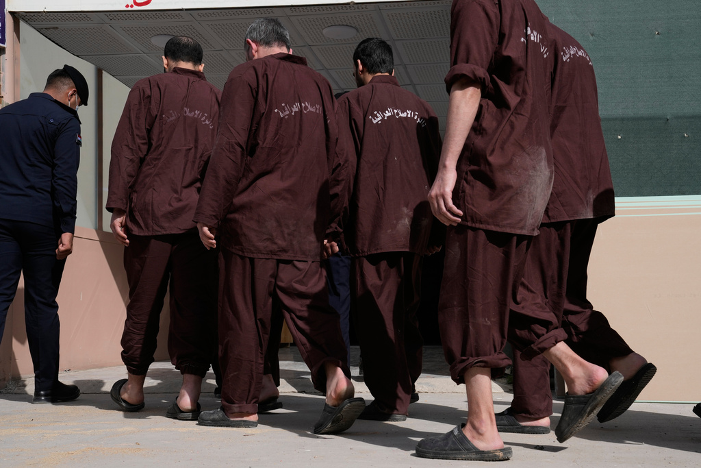 Iraqi security forces lead suspected Islamic State militants for questioning, after they were transferred from Syria to Iraq, at Al-Karkh Central Prison in Baghdad, Iraq, Thursday, Feb. 12, 2026. (AP Photo/Hadi Mizban)