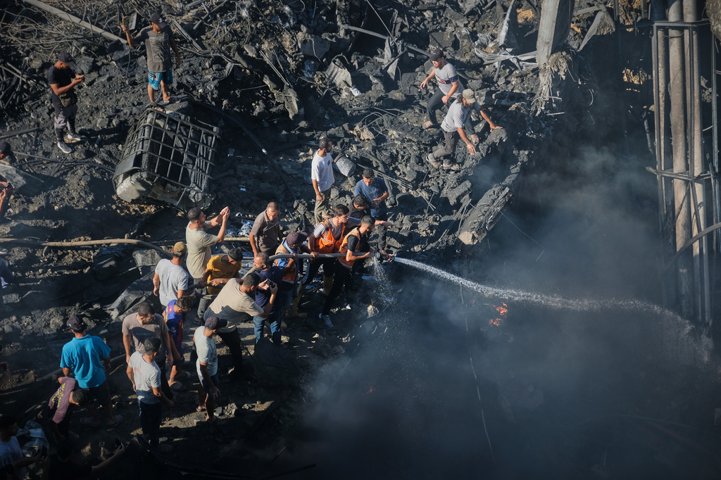 Palestinians try to extinguish a fire in the rubble of a destroyed building following an Israeli airstrike in Gaza City, Monday, Aug. 24, 2026. (AP Photo/Jehad Alshrafi)