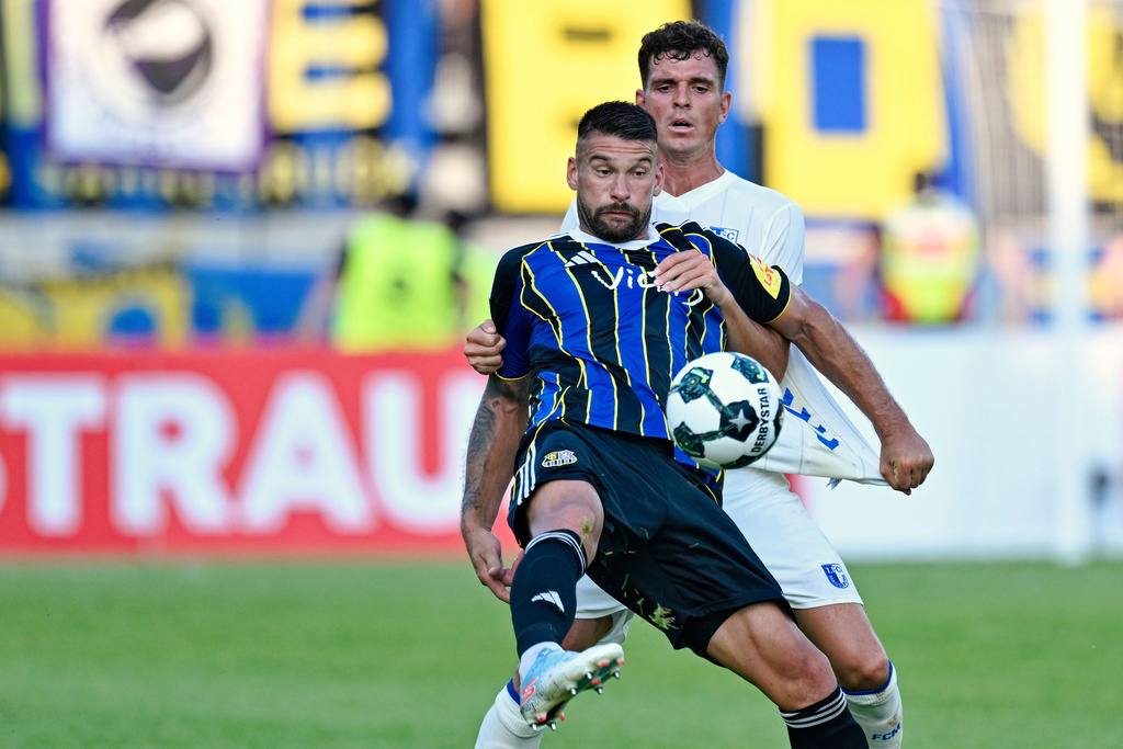 Saarbrücken's Kai Brünker, front, and Magdeburg's Tobias Müller in action during the DFB Cup first round soccer match between FC Saarbrücken and FC Magdeburg at Ludwigspark Stadium in Saarbrücken, Germany, Friday Aug. 15, 2025. (Uwe Anspach/dpa via AP)