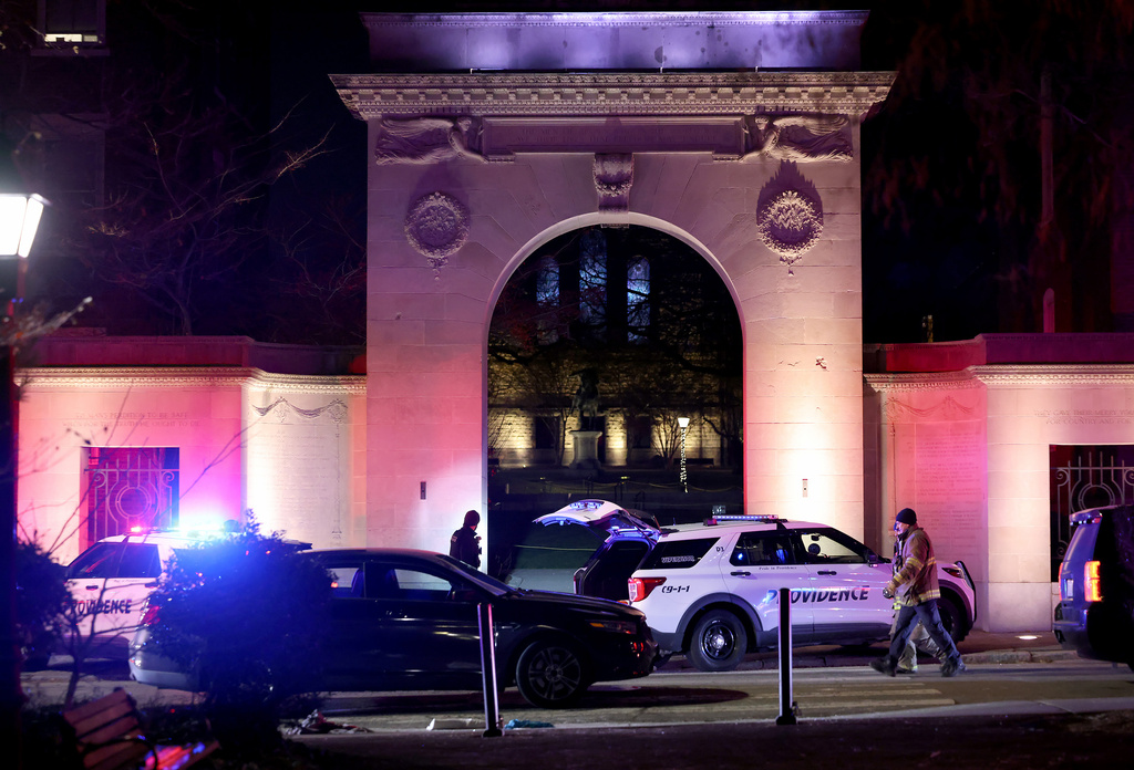 Police gather outside an entrance to Brown University in Providence, R.I., on Saturday, Dec. 13, 2025, during the investigation of a shooting. (AP Photo/Mark Stockwell)