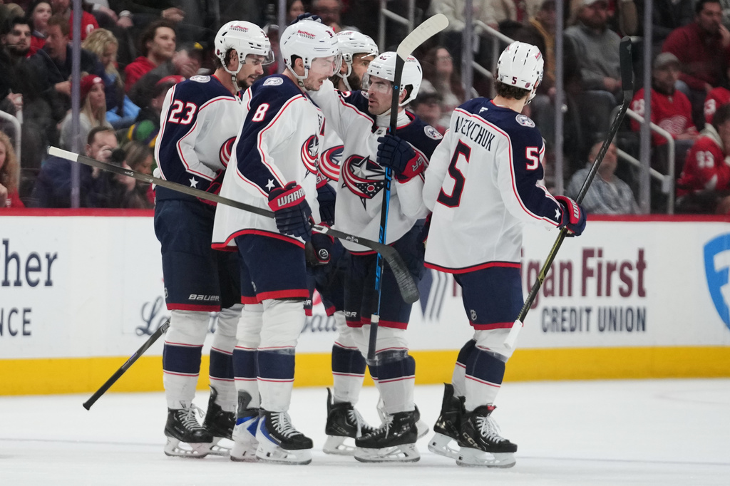Columbus Blue Jackets defenseman Zach Werenski (8) celebrates his goal with teammates against the Detroit Red Wings in the second period of an NHL hockey game Tuesday, April 7, 2026, in Detroit. (AP Photo/Paul Sancya)