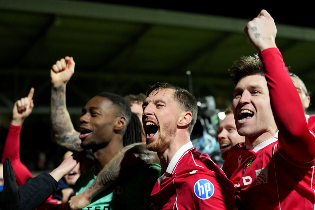 Wrexham's goalkeeper Arthur Okonkwo, left, celebrates with teammates after a penalty shootout at the end of the English FA Cup third round soccer match between Wrexham and Nottingham Forest in Wrexham, Wales, Friday, Jan. 9, 2026. (AP Photo/Jon Super)