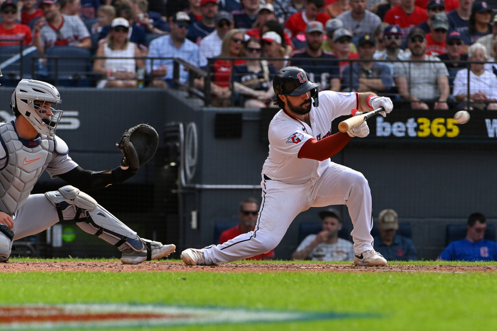 Cleveland Guardians' Austin Hedges, right, lays down a bunt as Detroit Tigers' Dillon Dingler watches during the fourth inning of a baseball game, Saturday, June 13, 2026, in Cleveland. (AP Photo/Phil Long)