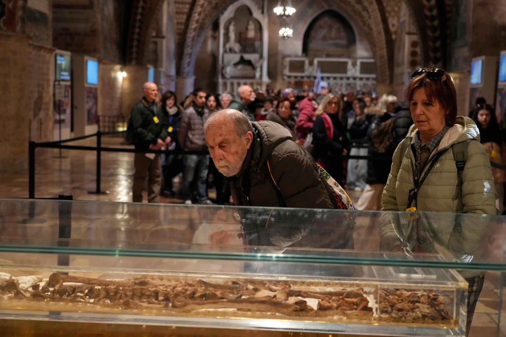 Pilgrims honor the bones of St. Francis during the first public display inside the St. Francis Basilica, marking the 800th anniversary of the saint death, in Assisi, Italy, Sunday, Feb. 22, 2026.(AP Photo/Gregorio Borgia)