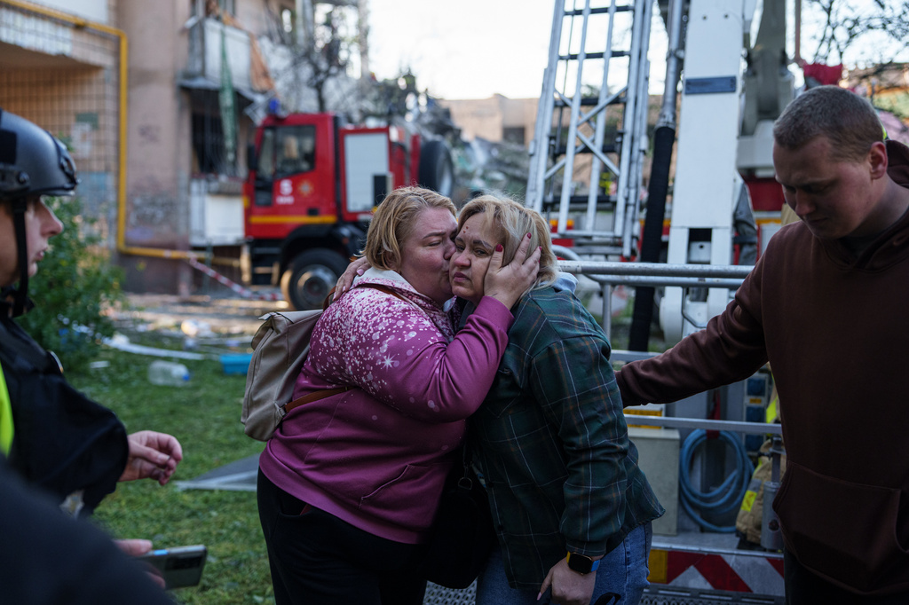 A woman kisses her relative evacuated from a house heavily damaged after a Russian strike on residential neighbourhood in Kyiv, Ukraine, on Thursday, May 14, 2026. (AP Photo/Evgeniy Maloletka)