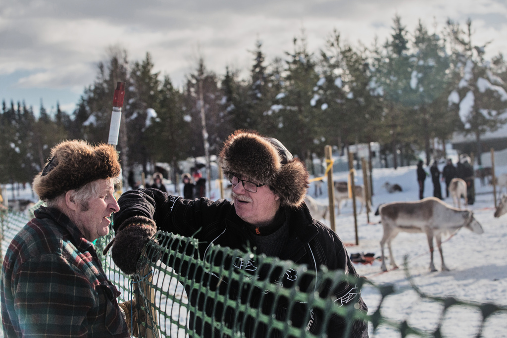 Reindeer herders Kalevi Simontaival, left, and Juhani Mantyranta, right, chat at the fence during the Salla Porocup reindeer sprint racing event, in Salla, Finland, March 7, 2026. (AP Photo/Aino Vaananen)