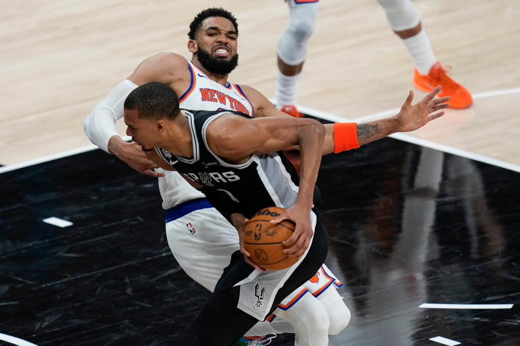 San Antonio Spurs forward Victor Wembanyama drives on New York Knicks center Karl-Anthony Towns, right, during the second half of Game 1 of the NBA Finals basketball series, Wednesday, June 3, 2026, in San Antonio. (AP Photo/David J. Phillip)