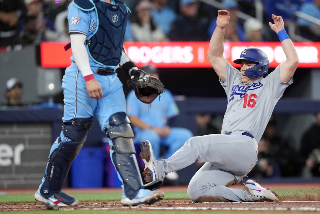 Los Angeles Dodgers Will Smith (16) slides into home plate for a run against the Toronto Blue Jays during the fourth inning of a baseball game in Toronto, Wednesday, April 8, 2026. (Nathan Denette/The Canadian Press via AP)