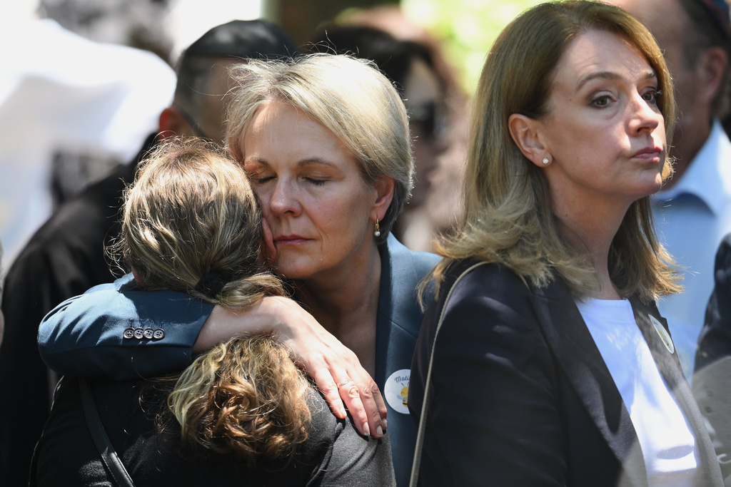 Tanya Joan Plibersek, centre, Minister for Social Services hugs a mourner at the funeral of Bondi Beach mass shooting victim 10-year-old Matilda, whose last name is being withheld at the request of her family, in Sydney, Thursday, Dec. 18, 2025. (AP Photo/Steve Markham)