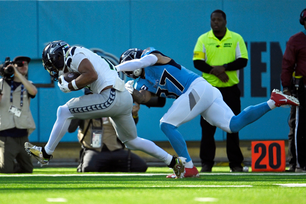 Seattle Seahawks wide receiver Jaxon Smith-Njigba, left, catches a touchdown pass ahead of Tennessee Titans safety Amani Hooker (37) during the first half of an NFL football game Sunday, Nov. 23, 2025, in Nashville, Tenn. (AP Photo/John Amis)