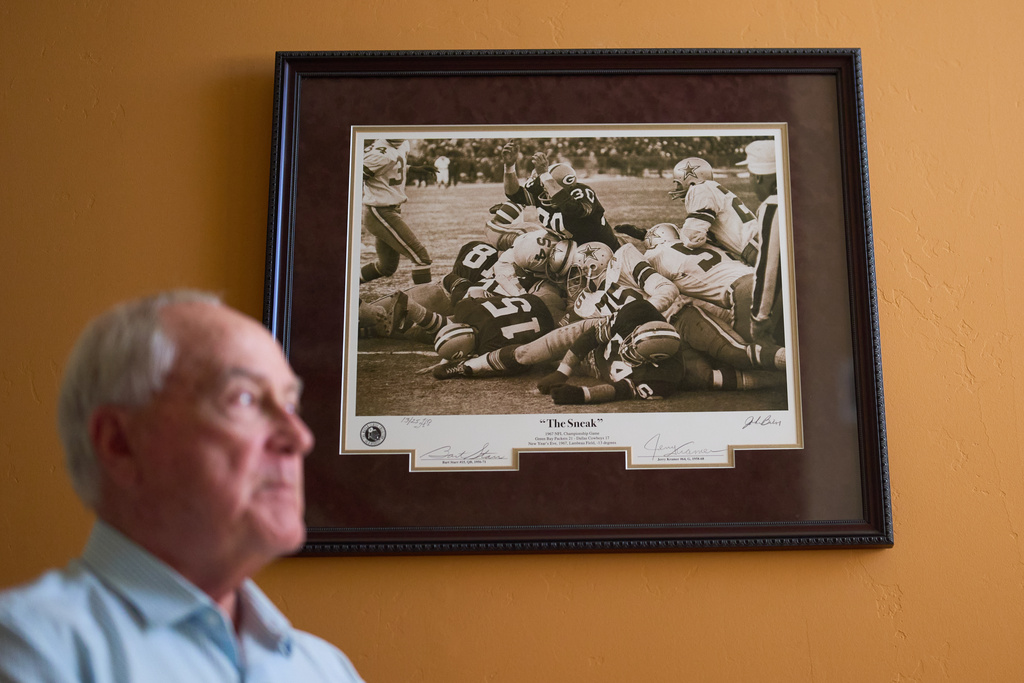 Photographer John Biever, who has shot every Super Bowl NFL football game, looks on in front of his photo from the 1967 NFL Championship Game at his home Tuesday, Jan. 20, 2026, in San Diego. (AP Photo/Gregory Bull)
