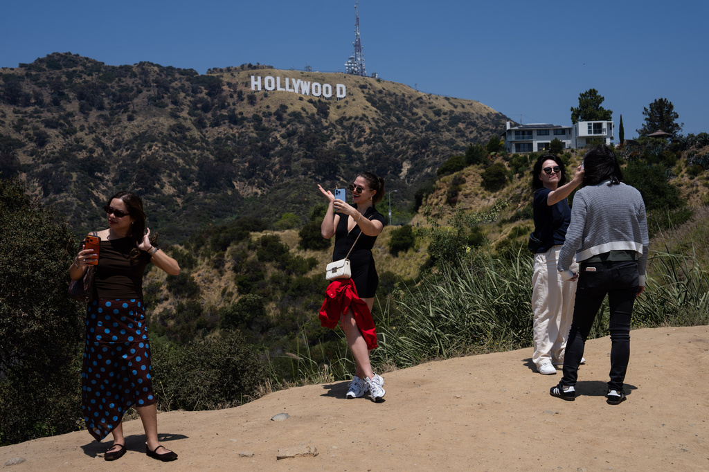 Tourists take selfies with the Hollywood sign in the background in Los Angeles, May 8, 2026. (AP Photo/Jae C. Hong)