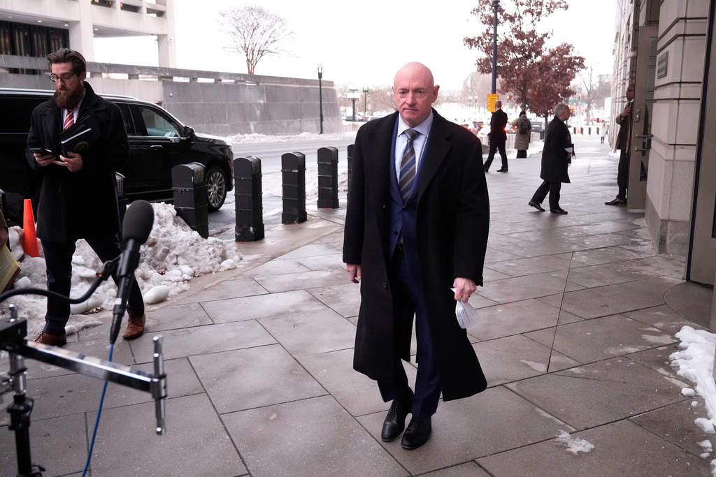 Sen. Mark Kelly, D-Ariz.,walks to speak to reporters outside of federal court in Washington, Tuesday, Feb. 3, 2026. (AP Photo/Mark Schiefelbein)