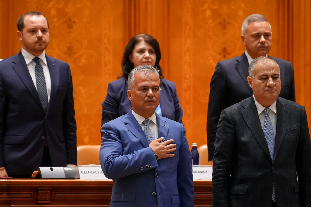 Romanian Prime Minister designate Adrian Vestea, centre, listens to the national anthem during a joint parliament session called to give a vote of confidence for the new government team in Bucharest, Romania, Monday, June 22, 2026. (AP Photo/Vadim Ghirda)
