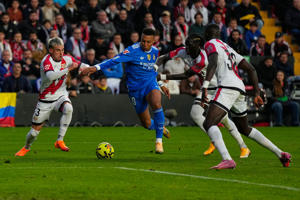 Rayo's Pep Chavarria, left, and teammates stop Real Madrid's Kylian Mbappe, center, from scoring during a Spanish La Liga soccer match between Rayo Vallecano and Real Madrid in Madrid, Spain, Sunday, Nov. 9, 2025. (AP Photo/Manu Fernandez)