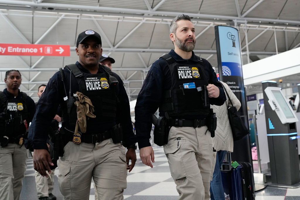Federal immigration officers walk though the terminal 1 at O'Hare International Airport in Chicago, Tuesday, March 24, 2026. (AP Photo/Nam Y. Huh)