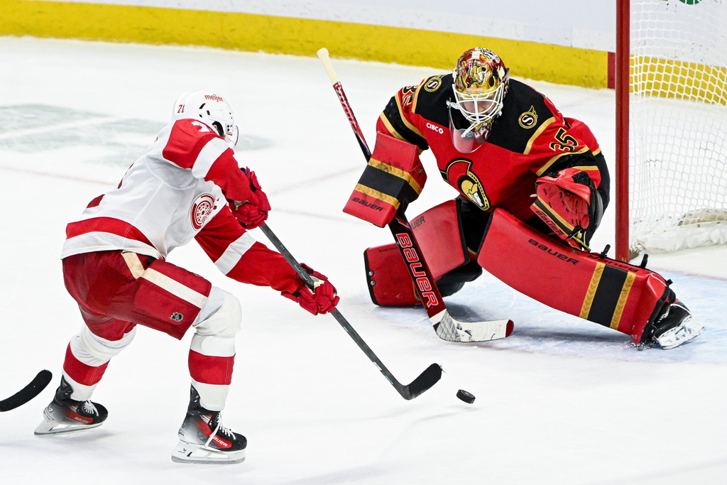 Detroit Red Wings' Dylan Larkin (71) scores on Ottawa Senators' goaltender Linus Ullmark (35) during overtime of an NHL hockey game, in Ottawa, Ontario, Thursday, Feb. 26, 2026. (Spencer Colby/The Canadian Press via AP)