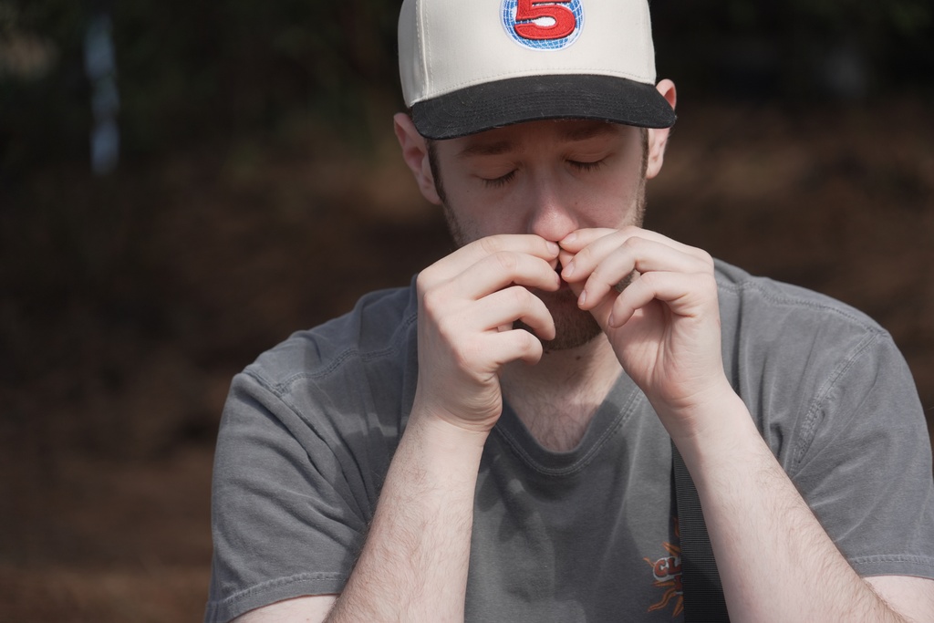 CORRECTS SPELLING TO JC Alan Mintz smells a crushed conifer twig during a "forest bathing" session at the JC Raulston Arboretum in Raleigh, N.C., on Sunday, March 22, 2026. (AP Photo/Allen G. Breed)