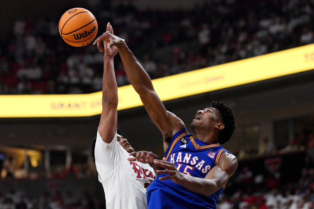 Kansas forward Bryson Tiller (15) blocks a shot by Texas Tech forward Lejuan Watts, left, during the first half of an NCAA college basketball game, Monday, Feb. 2, 2026, in Lubbock, Texas. (AP Photo/Annie Rice)