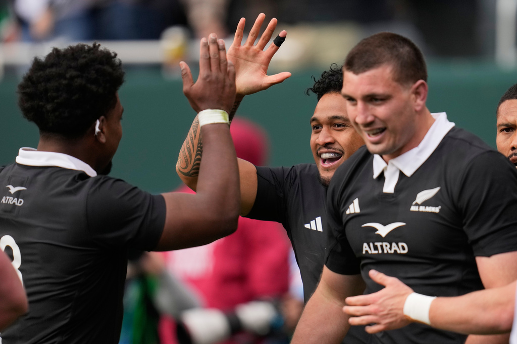 New Zealand's Leicester Fainga'anuku, centre, celebrates with teammate Peter Lakai, left, after their team's first try during the rugby international between the All Blacks and Ireland in Chicago, Saturday, Nov. 1, 2025. (AP Photo/Erin Hooley)