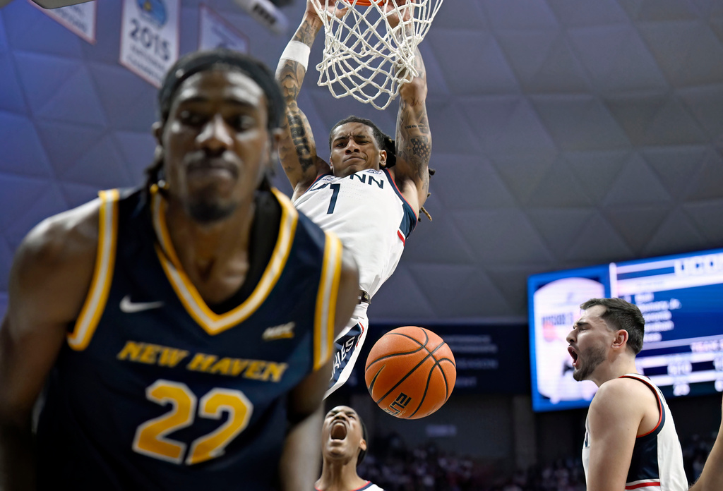 UConn guard Solo Ball (1) reacts toward New Haven guard Maison Adeleye (22) after Adeleye fouled him while dunking during the first half of an NCAA college basketball game, Monday, Nov. 3, 2025, in Storrs, Conn. (AP Photo/Jessica Hill)