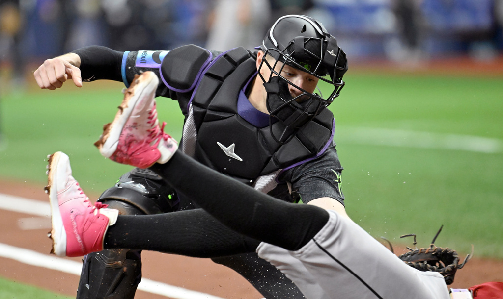 Arizona Diamondbacks' Geraldo Perdomo, bottom, scores before a tag byTampa Bay Rays catcher Hunter Feduccia, top, during the first inning of a baseball game Saturday, June 27, 2026, in St. Petersburg, Fla. (AP Photo/Jason Behnken)