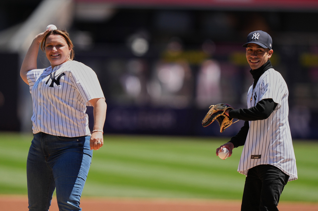 Golden Tempo trainer Cherie DeVaux, left, and Jose Ortiz throw out a ceremonial first pitch before a baseball game between the New York Yankees and the Texas Rangers Thursday, May 7, 2026, in New York. (AP Photo/Frank Franklin II)