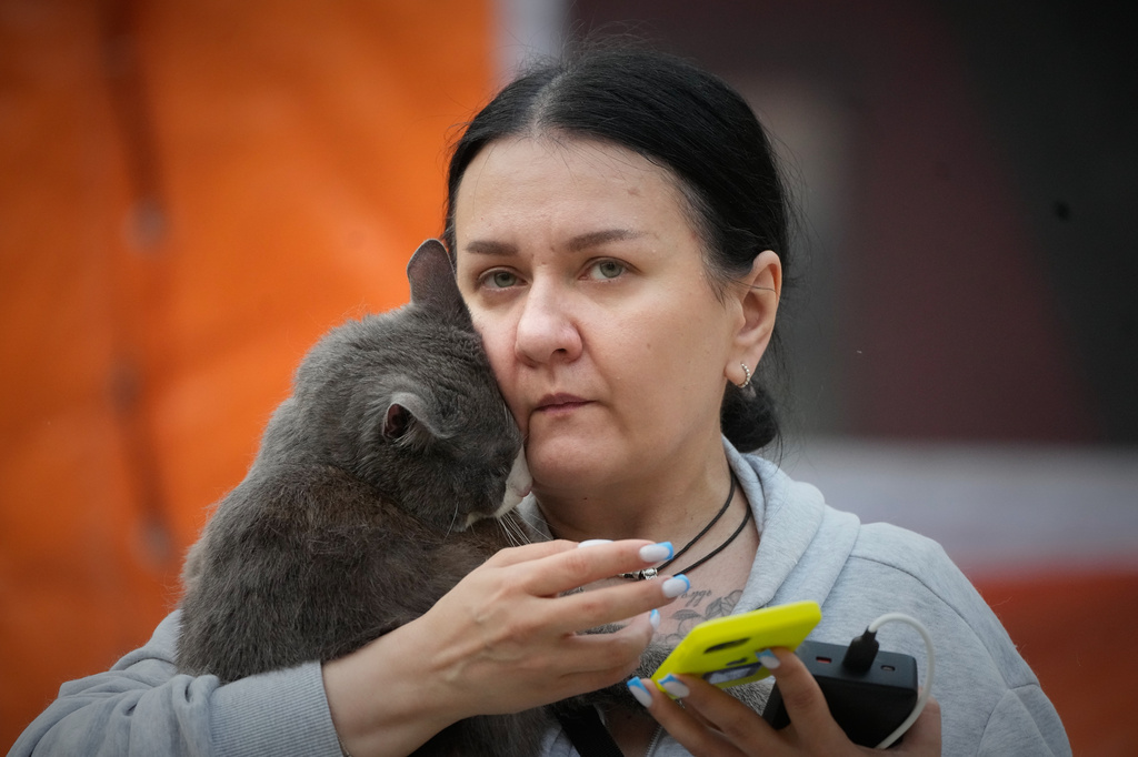 Frightened by explosions, a cat cuddles up to its owner during search and rescue works at the damaged residential building following Russia's missile attack in Kyiv, Ukraine, Monday, July 6, 2026. (AP Photo/Efrem Lukatsky)