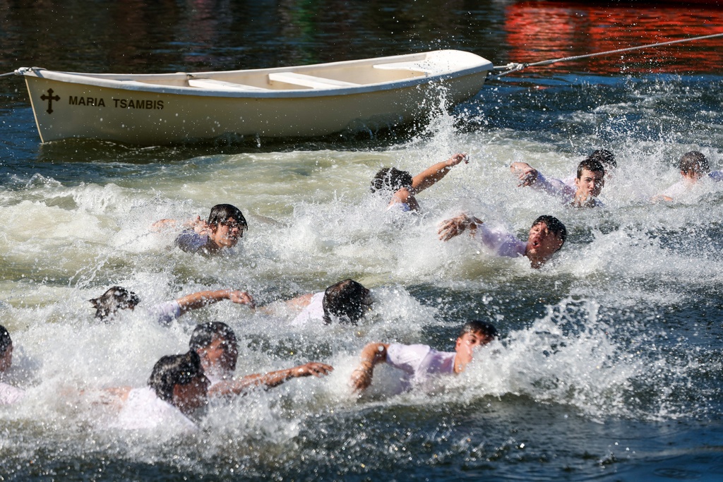 Cross divers swim quickly towards the cross during the annual cross dive in the Spring Bayou, part of the Epiphany celebration on Tuesday, Jan. 6, 2026, in Tarpon Springs, Fla. (Jefferee Woo/Tampa Bay Times via AP)
