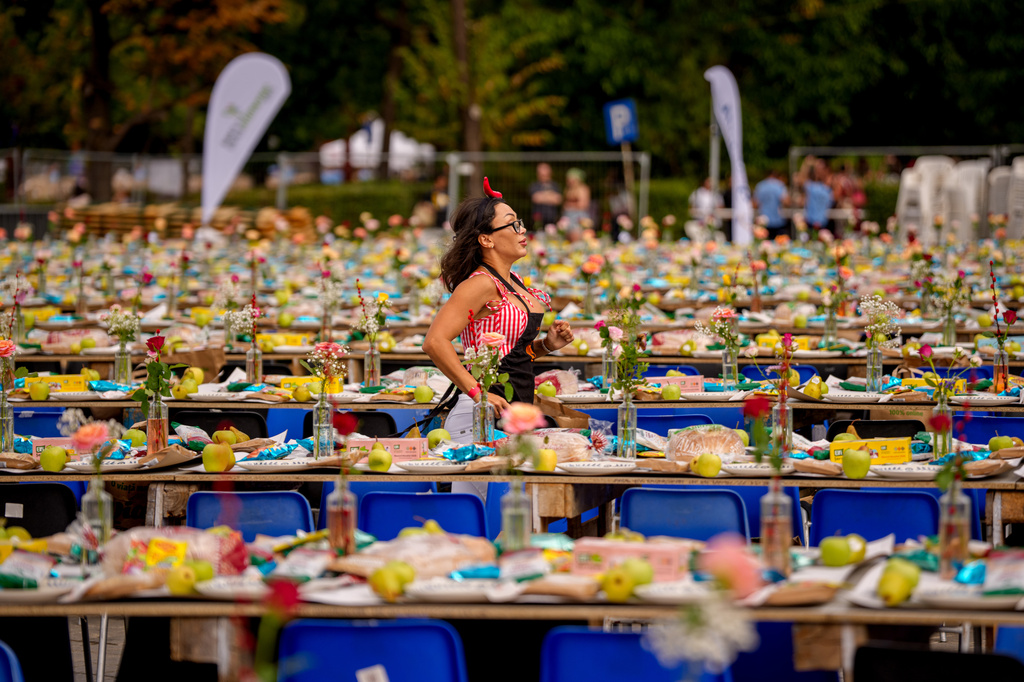 A woman runs along a 5-kilometer (3.1 miles) long "Uniting Table", made from recycled materials, during a Guinness World Record event to raise money for a children's psychiatric facility, in Bucharest, Romania, Saturday, Sept. 12, 2026. (AP Photo/Andreea Alexandru)