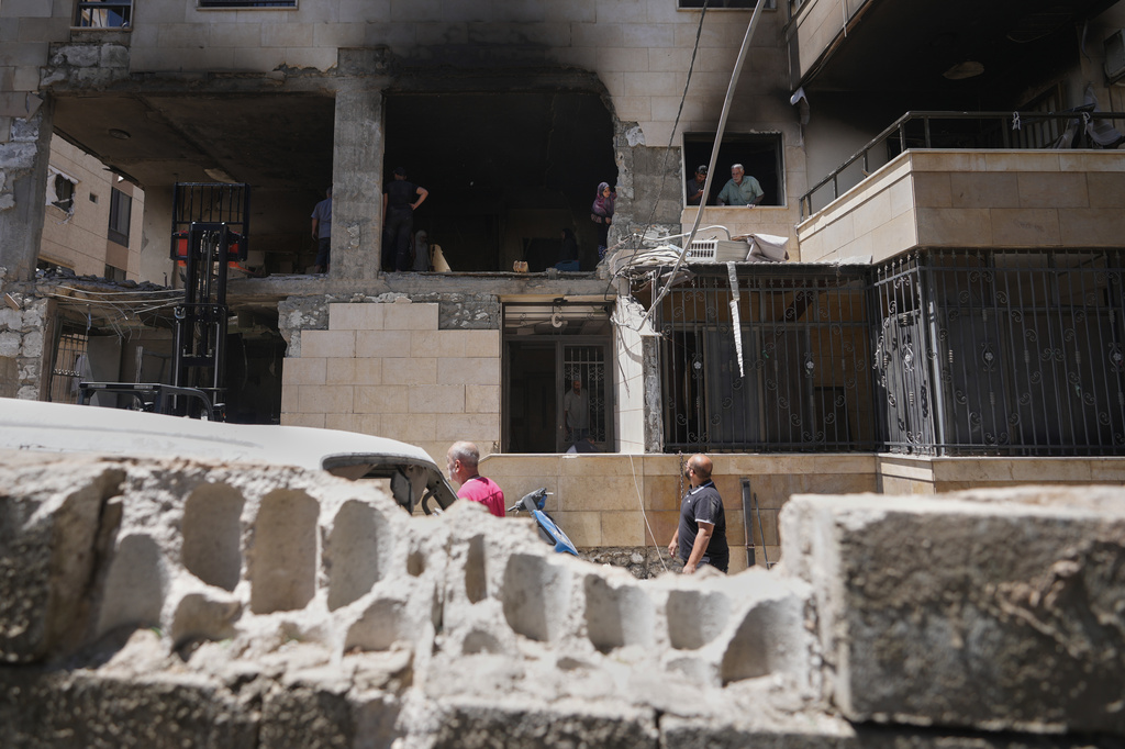 Residents inspect an apartment building damaged in an Israeli airstrike a day earlier in Choueifat, in Dahiyeh, Beirut's southern suburbs, Lebanon, Friday, May 29, 2026. (AP Photo/Hassan Ammar)