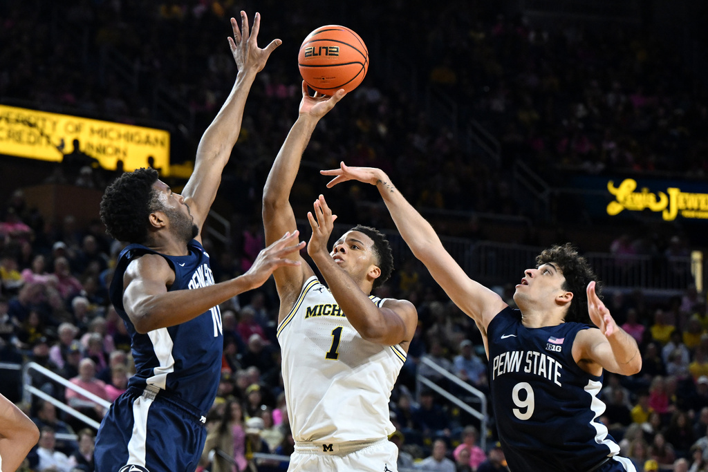 Michigan guard Trey McKenney (1) shoots the ball between Penn State forward Josh Reed (10) and Penn State guard Melih Tunca (9) in the first half of an NCAA college basketball game in Ann Arbor, Mich., Thursday, Feb. 5, 2026. (AP Photo/Lon Horwedel)