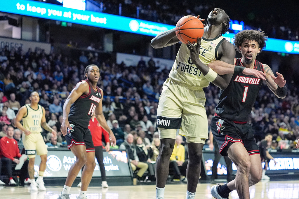 Wake Forest forward Omaha Biliew (0) is fouled by Louisville guard J'vonne Hadley (1) during the first half of an NCAA college basketball game, Saturday, Feb. 7, 2026, in Winston-Salem, N.C. (AP Photo/Matt Kelley)
