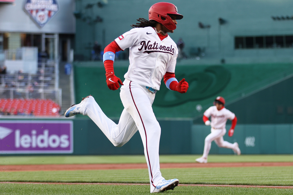 Washington Nationals' CJ Abrams, foreground, runs to score during the first inning of a baseball game against the Atlanta Braves, Monday, April 20, 2026, in Washington. (AP Photo/Daniel Kucin Jr.)