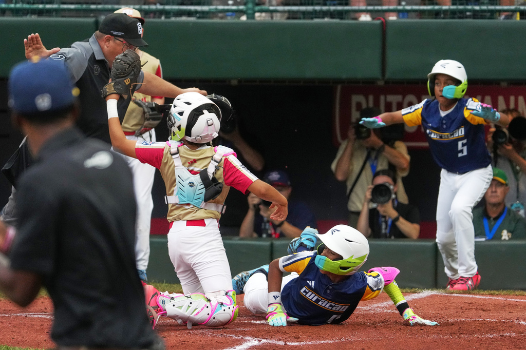 Curacao's Jordan Richards, bottom, slides safely home with the second run to score on a single by Curacao's Shardijon De Lanoi off Henderson, Nev.'s pitcher Payton Hinsen during the second inning of the Little League World Series Championship game in South Williamsport, Pa., Sunday, Aug. 30, 2026. (AP Photo/Gene J. Puskar)
