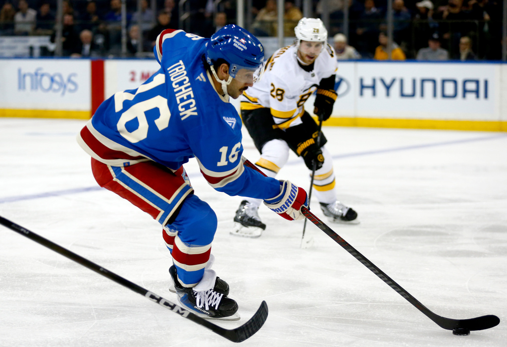 New York Rangers center Vincent Trocheck (16) skates past Boston Bruins center Elias Lindholm (28) during the first period of an NHL hockey game Monday, Jan. 26, 2026, in New York. (AP Photo/John Munson)
