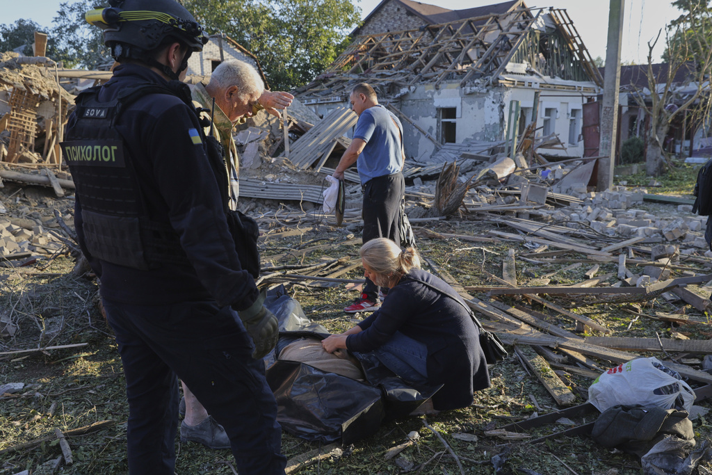 Relatives mourn by a dead body after a Russian strike in Zaporizhzhia, Ukraine, Monday, Sept. 22, 2025. (AP Photo/Kateryna Klochko)