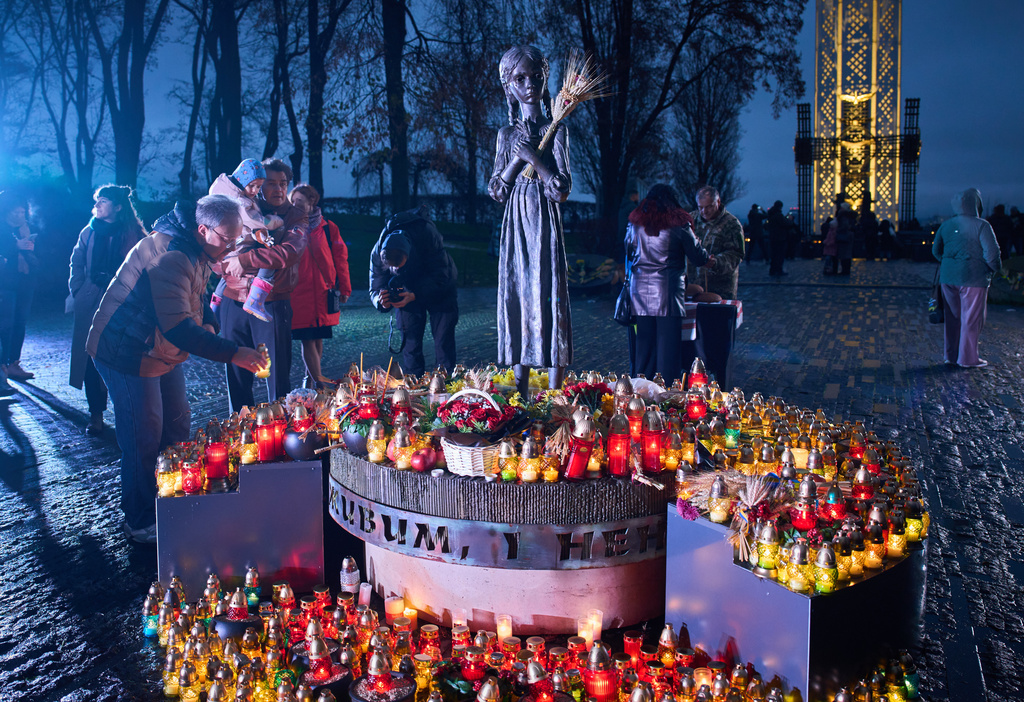 People light candles and lay flowers at the monument of the victims of the Holodomor, Great Famine, which took place in the 1930's and that killed millions, in Kyiv, Ukraine, Saturday, Nov. 22, 2025. (AP Photo/Efrem Lukatsky)