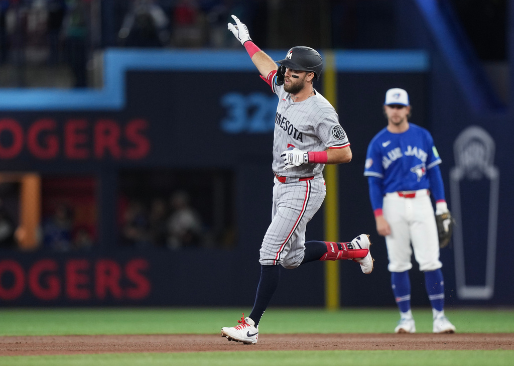 Minnesota Twins' Kody Clemens, foreground, rounds the bases after hitting a solo home run against the Toronto Blue Jays during third-inning baseball game action in Toronto, Sunday, April 12, 2026. (Nathan Denette/The Canadian Press via AP)